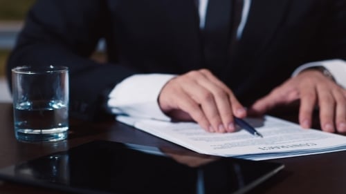 Geschäftsmann unterschreibt eine Reihe von Dokumenten