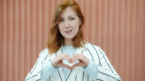 Woman Makes Heart Shape with Hands