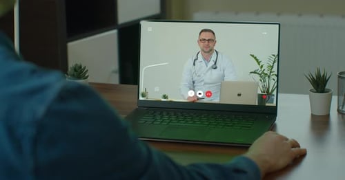 Man Has Video Call with Doctor on Laptop