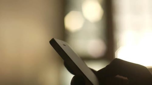Fingers Interacting With a Glowing Smartphone Screen