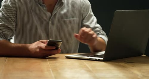 Man using smartphone and laptop