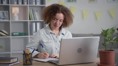 Young Woman Works at Home on Laptop