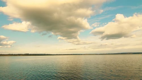 Cinematic Aerial Sunset View Over the Lake. Clouds Hung Over the Horizon and the Lake. Twilight