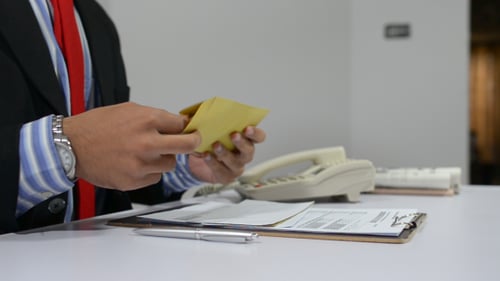 Adult Examines Paperwork at a Desk