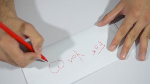 Hands Opening Envelope and Writing a Love Letter