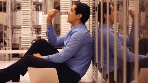 Stressed technician sitting in hallway