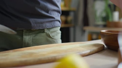 Person Slices Cherry Tomatoes on Cutting Board