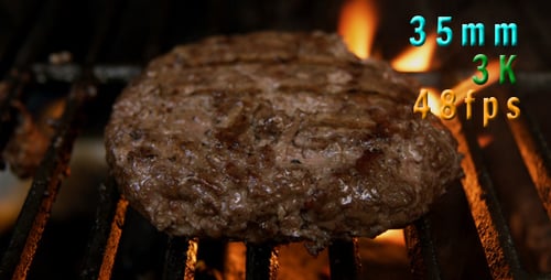 Hamburger Patty Cooking on Grill with Flames