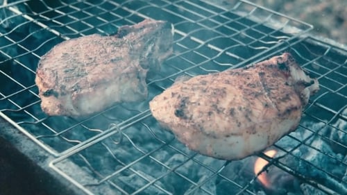 Juicy Steaks Cooking Over Coals on Grill