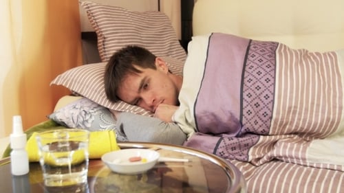 Homme malade avec serviette humide sur le front