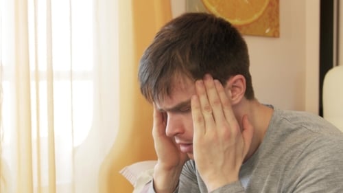 Man Massaging Temples Suffering from Headache