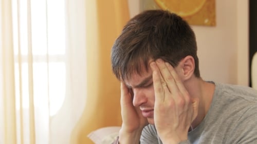 Man Massaging Temples During Daytime