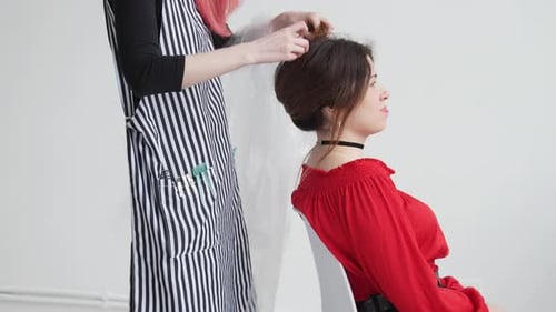 Hairstylist Creating Elegant Up-Do in Studio