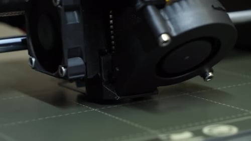 Extreme close-up of a 3D printer heading process printing a industrial part.