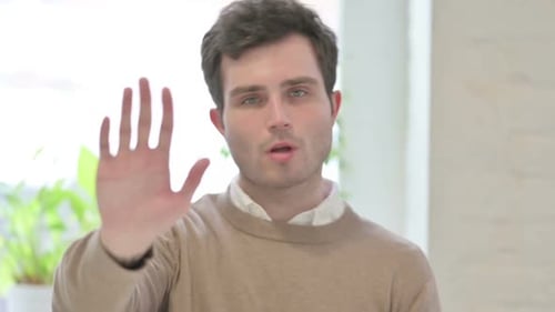 Young Adult Making Stop Gesture Indoors