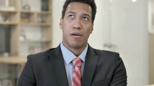 Young Businessman Ponders a Solution in Office