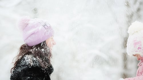 Woman And Child Playing With Snow In Winter