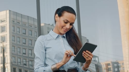 Woman Using Tablet Outside in City Setting
