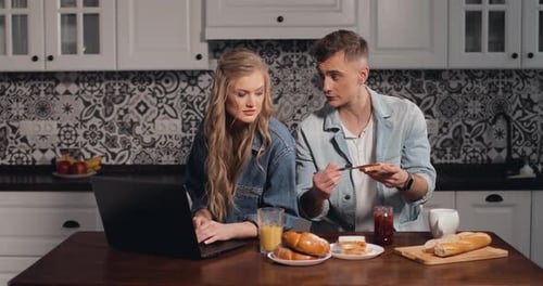 Young Couple Having Breakfast in Kitchen