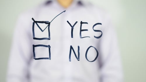 Person Checks Yes Box on Glass Screen