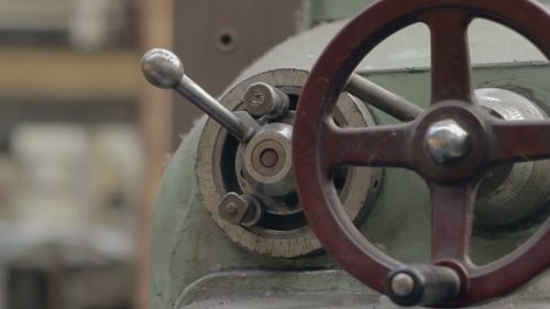 Man Adjusts Old Factory Machine