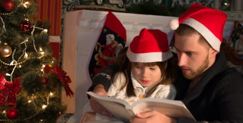 Father and Daughter Reading Book at Christmas
