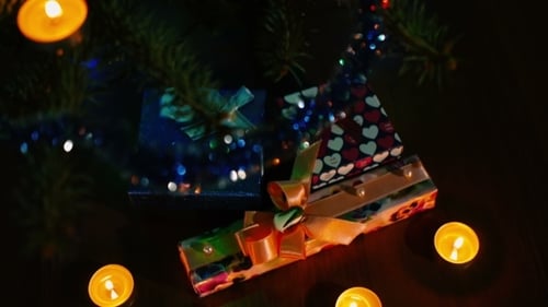 Christmas gifts under the tree decorated with baubles garland and candles. the atmosphere of the fes