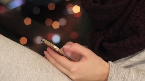 Smartphone Use at Night With City Bokeh