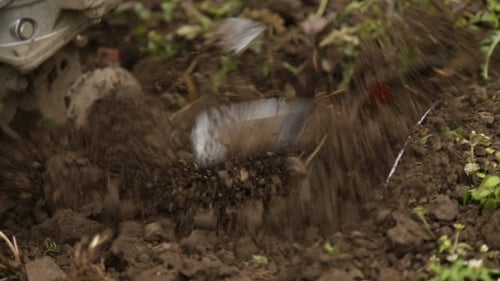 Machine Tilling Rich Brown Soil in Garden