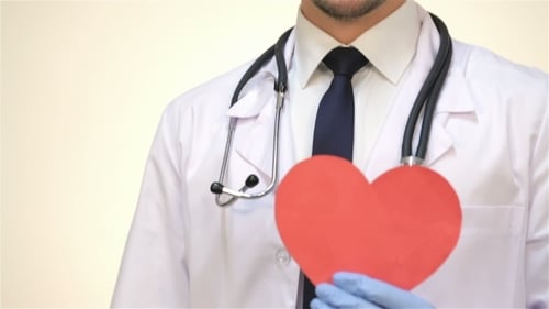 Smiling Male Doctor With a Paper Heart