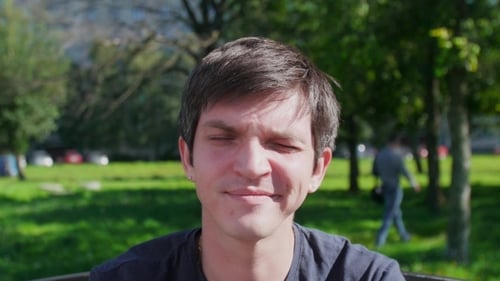 Young Man Smiling and Giving Thumbs Up in Park