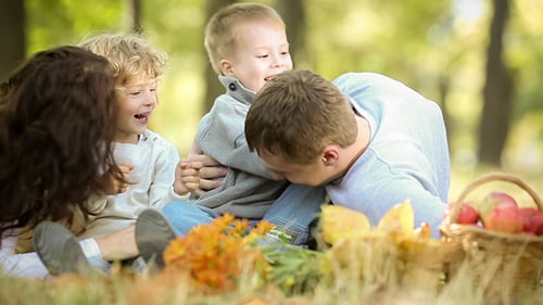 Happy Family Relaxing Together in Autumn Park