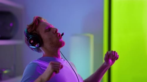Excited Gamer Cheers While Wearing Headset
