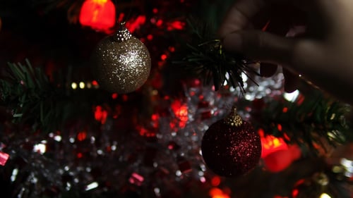 Decorating Christmas Tree with Ornaments at Night