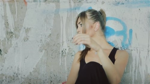 Woman Posing Against Graffiti Wall in City