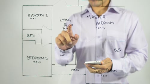 Adult Using Smartphone With House Blueprint Drawing
