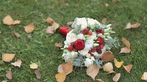 Wedding Bouquet on Green Grass with Autumn Leaves