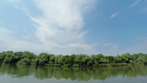 Stripe of Forest Between Cloudy Sky and River