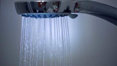 Shower Head Streaming Water in Close Up