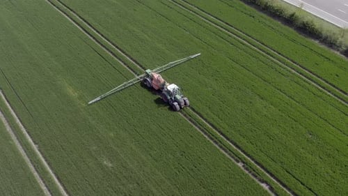 Tractor Spraying Lush Green Field from Above