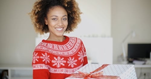 Smiling Woman Holds Wrapped Christmas Gift