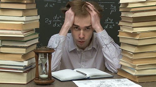 Young Man Studying with Books and Hourglass