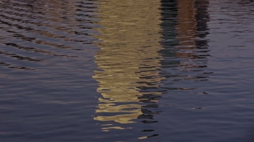 Abstract Rippling Water Reflects Building During Golden Hour