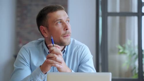 Serious Man Student Sit at Home Office Desk with Laptop Thinking of Inspiration Search Problem