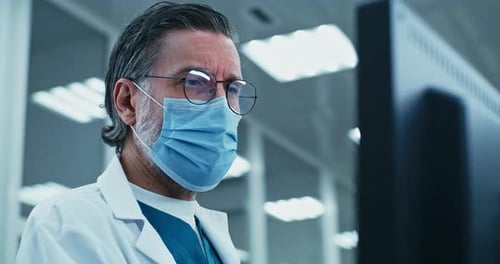 Médecin d'âge moyen utilisant un ordinateur en laboratoire
