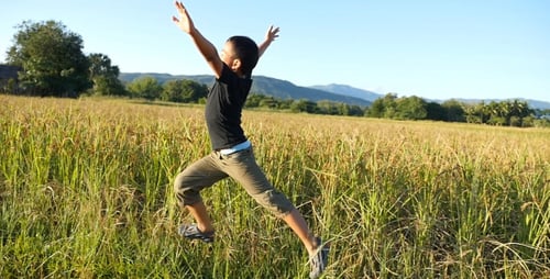 Boy Running and Playing in Grassy Rural Field