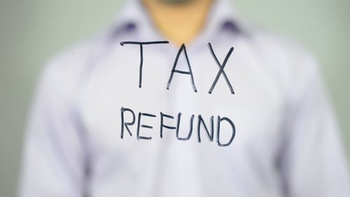 Writing Tax Refund on Clear Surface