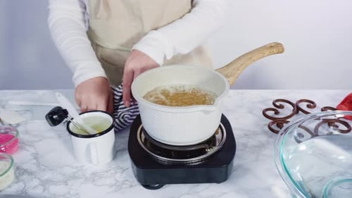 Cook Stirring Bubbling Liquid on Electric Burner