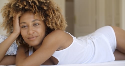 Woman with Golden Curly Hair Relaxing in Bed