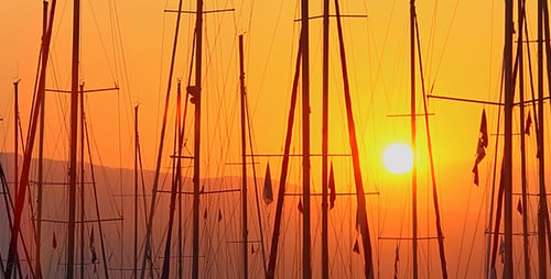 Sailboat Masts Silhouetted Against Golden Ocean Sunset